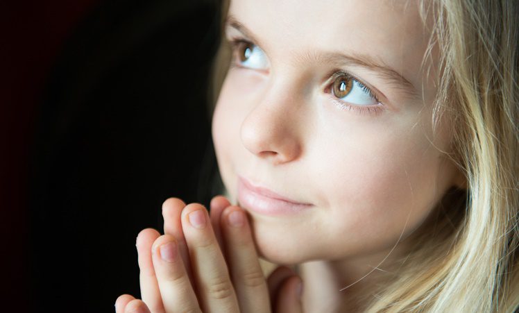 Close Up Of Little Girl Praying.