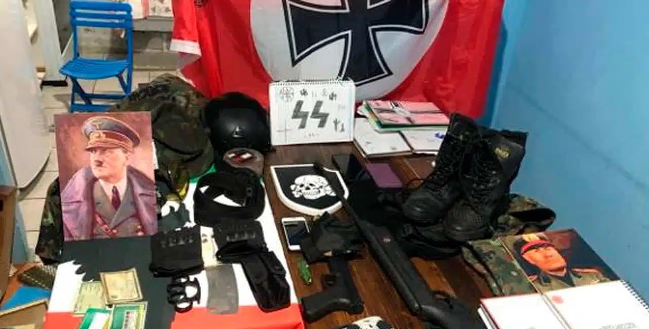 Um Adolescente De 14 Anos Suspeito De Planejar Um Ataque A Uma Escola Foi Apreendido Com Materiais Nazistas Em Casa.